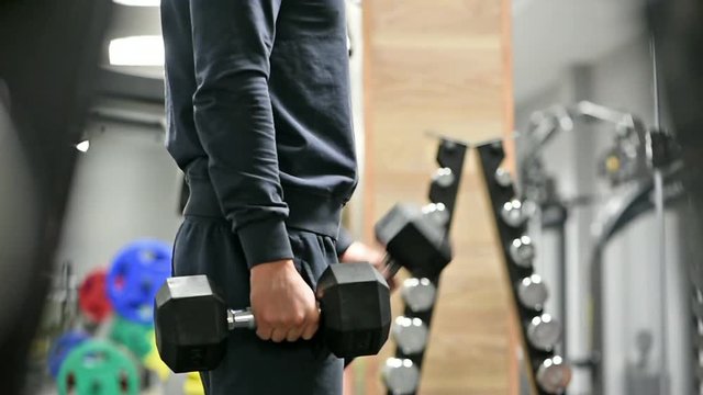 Man doing exercises with dumbbell in gym