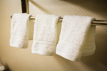 three Hanging white towels in the bathroom