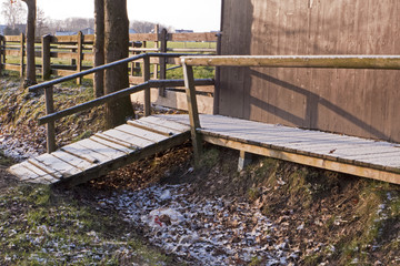 Fototapeta premium Ein Übergang aus Holz über einen verschneiten Graben