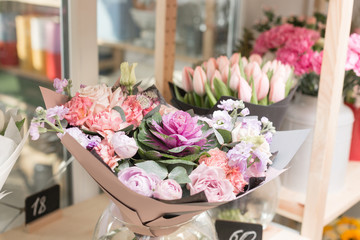 Flower shop concept. Different varieties fresh spring flowers in refrigerator room for flowers. Bouquets on shelf, florist business.