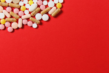 Medication white colorful round tablets arranged abstract on red color background. Aspirin, capsule pills for design. Health, treatment, choice healthy lifestyle concept. Copy space for advertisement.