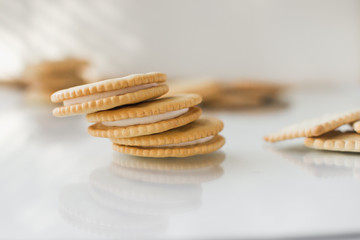A round cookie with white filling on a light background