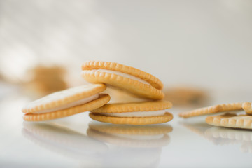 A round cookie with white filling on a light background