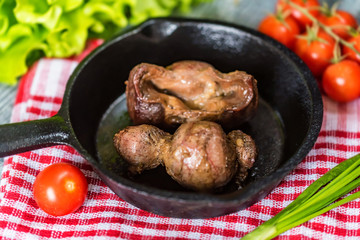 Tasty roasted chicken giblets in pan