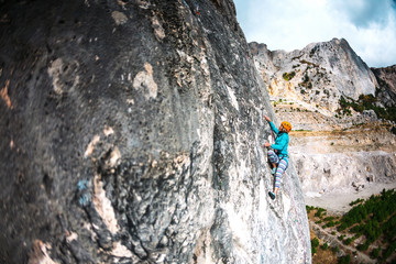The girl climbs the rock.