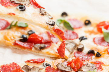 A hot pizza slice with dripping melted cheese. Isolated on white.