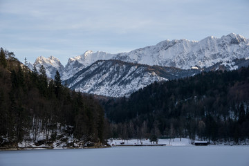 Obraz na płótnie Canvas Frozen alpine lake in the mountains of Austria with beautiful peaks setting the backdrop