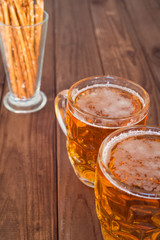 Beer mugs on wooden bar benches.