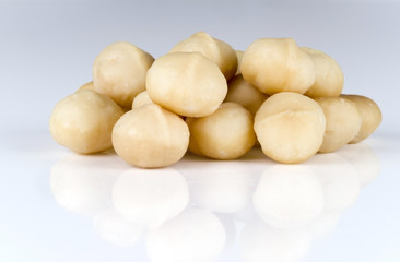 A handful of kernels of macadamia nuts on a light background.