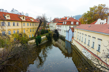 Beautiful view of a street with old water mill in a canal in center of Prague, Concept of Europe travel © Leonid