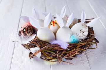 Colorful easter eggs with bunny ears in the nest