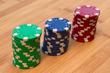 Casino chips on a wooden table. This image can be used to represent gambling or risk taking. 