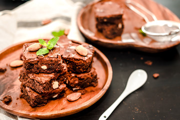 Delicious chocolate brownie with mint and almonds a wooden plate