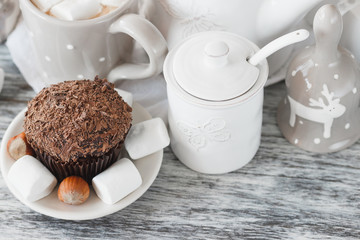 Cups with cacao and marshmallow, cupcakes and different decorations