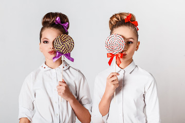 Beautiful teenage model girls in pink tutu or tulle skirts with colorful  lollipops in studio on white background  isolated