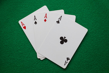 Playing cards four aces on green felt 