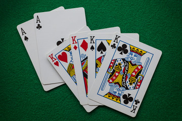 Full house two aces and  four kings on green felt 