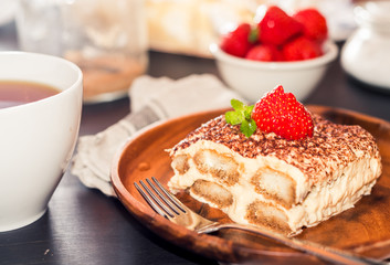 Homemade tiramisu cake decorated with strawberries Italian cuisine, Selective focus