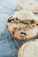 Close up of broken in two traditional American homemade Chocolate chips cookies with semi-sweet chocolate chunks fresh from the oven on wire cooling rack on marble surface