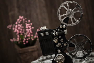 Fototapeta premium Small nostalgic decorative film camera on brown wooden background