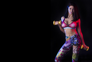 Fototapeta na wymiar Sport girl in colorful leggings on the black background.