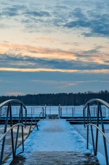 Naklejka premium Afternoon winter landscape. A pier over a beautiful frozen lake.