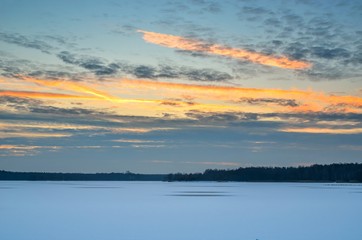Afternoon winter landscape. Beautiful sky above a frozen lake.