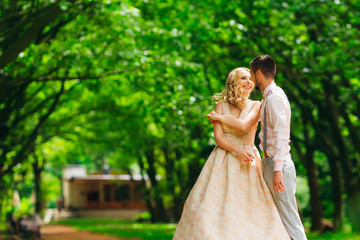 guy hugging his girlfriend during dancing in the green park and she laughs