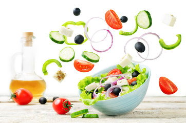 Greek Salad with flying ingredients to prepare it