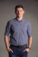 Portrait of smiling man in blue shirt isolated on gray studio background posing to the camera