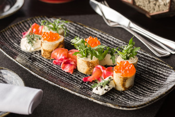 Pancakes with red caviar on the black dish. Russian Maslenitsa.