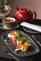 Pancakes with red caviar on the black dish. Russian Maslenitsa.