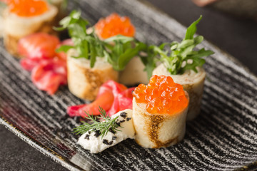 Pancakes with red caviar on the black dish. Russian Maslenitsa.