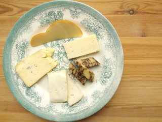 Cheese plate with fruits and nuts.  Cheddar sustained in porter, cheddar ordinary, Scamorza, Taleggio, cheese with blue mold.