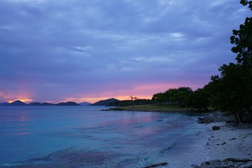 Obraz premium Sunset over a tropical beach and the Caribbean Sea in St John, U.S. Virgin Islands