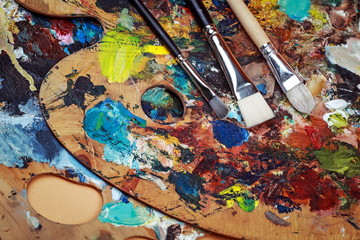 Макрофотография палитры искусства с красочными смешанными красками и щетками