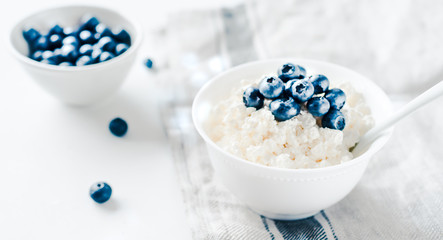 Cottage cheese with blueberries in a bowl on a table