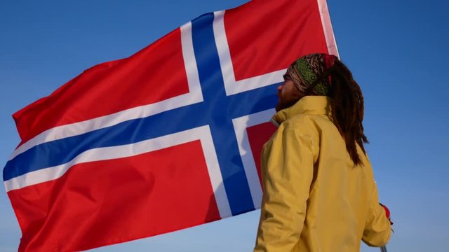 Close-up of a Norwegian against a blue sky with the flag of Norway. Support for the national team