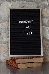 letterboard with "workout or pizza"