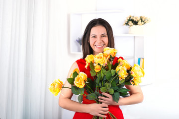 Portrait of the nice woman of the brunette with long hair and bouquet of yellow roses.