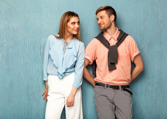 Fashion girl and guy in outlet clothes posing on a blue background. Valentines Day.