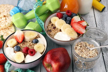 muesli with dairy and fruit, healthy lifestyle. bowl of cereal, fruit and dumbbell - Powered by Adobe