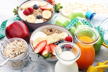 muesli with dairy and fruit, healthy lifestyle. bowl of cereal, fruit and dumbbell
