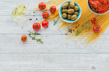 Ingredients for preparation pasta spaghetti - tomato, olive oil, spices, herbs, green olives, tomato sauce
