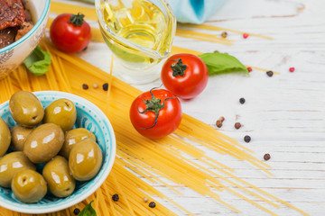 Ingredients for preparation pasta spaghetti - tomato, olive oil, spices, herbs, green olives, tomato sauce