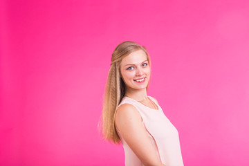 Fototapeta na wymiar Pretty young woman smiling against a pink background.