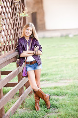 Stylish teen girl 15-16 year old wearing trendy clothes posing outdoors. Looking at camera