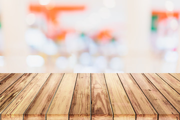 Empty wooden table with blur shopping mall background.