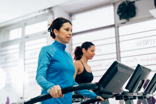 Mature woman running on treadmill in gym