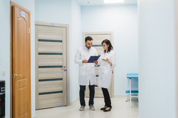 Two doctors discussing diagnosis while walking